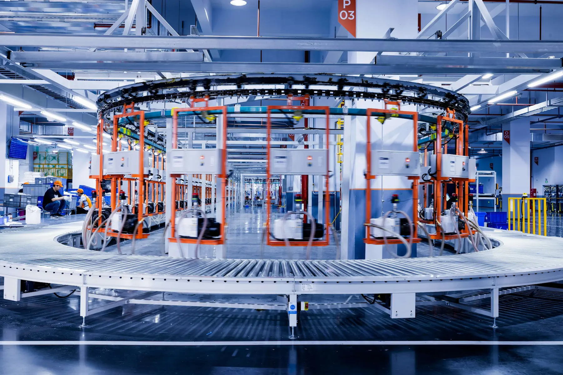 Large industrial machine on a manufacturing floor with workers present