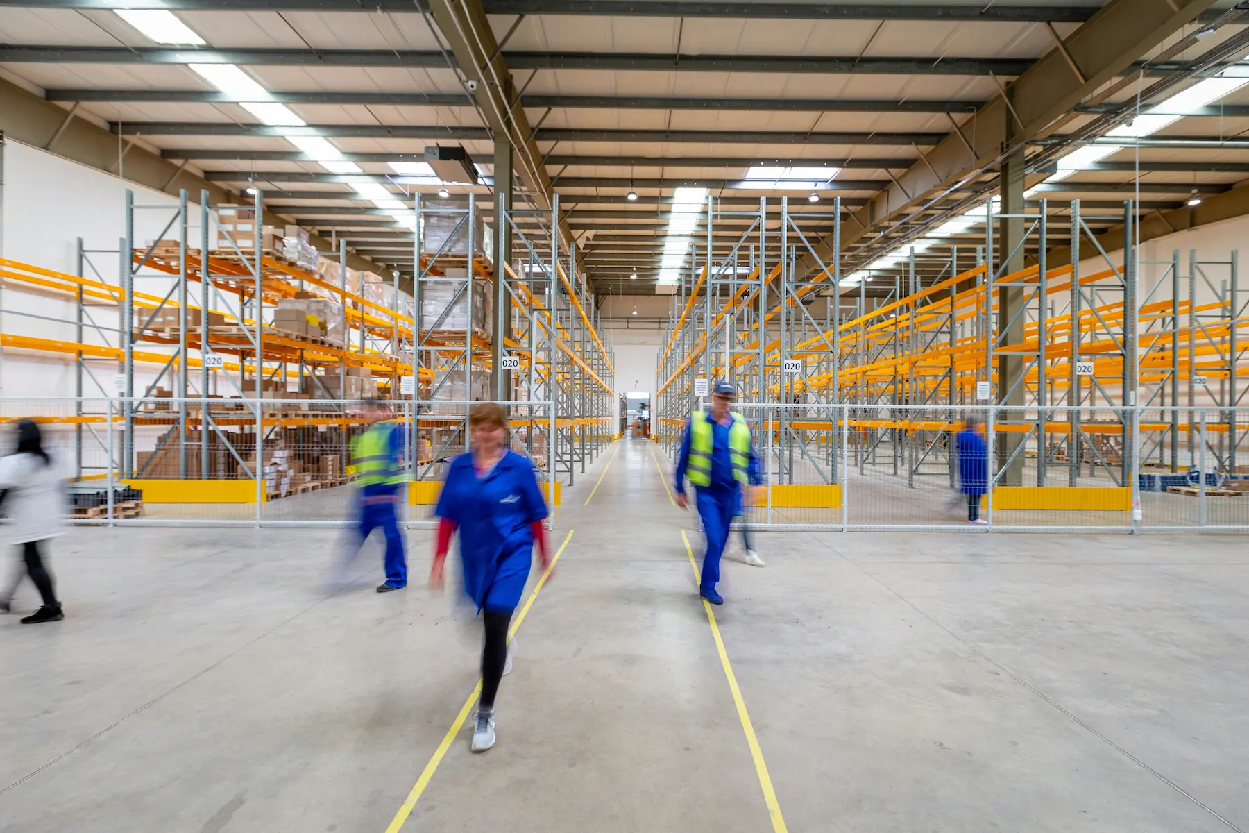 Workers walking through a warehouse aisle during operations