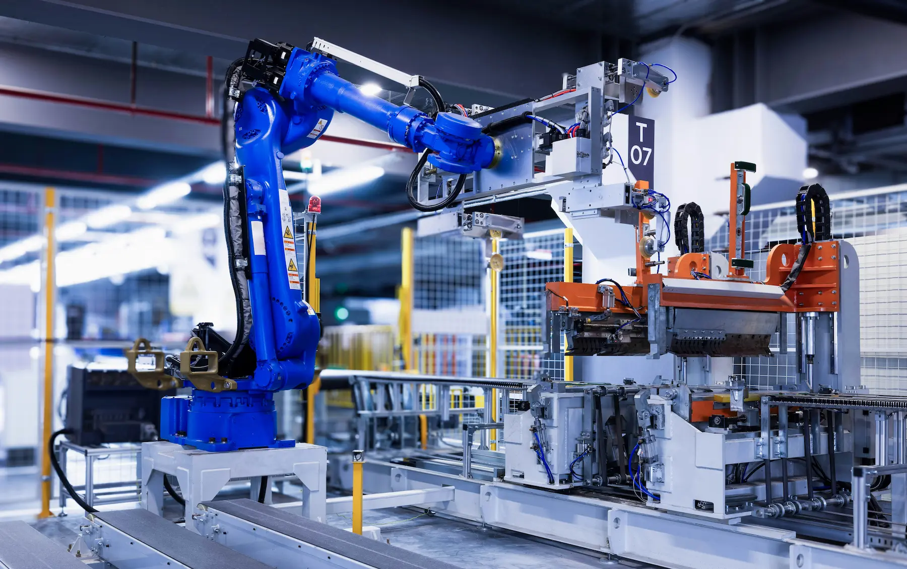 Blue industrial robot arm on a manufacturing production line